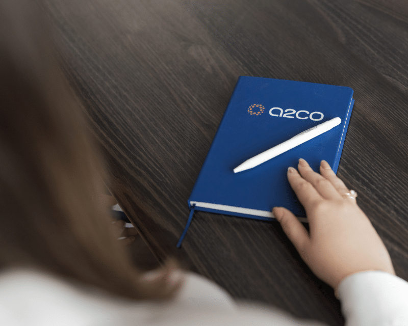 A2CO notebook and pen on a desk held by A2CO's Junior Advisory Kate Taliana Gatt