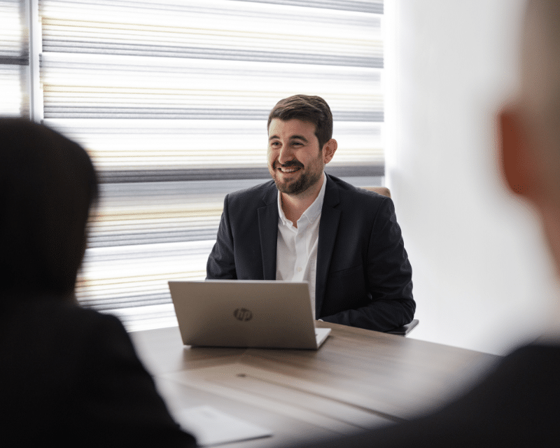 Desmond Pace Hili, AML Support Officer with his laptop attending a meeting.