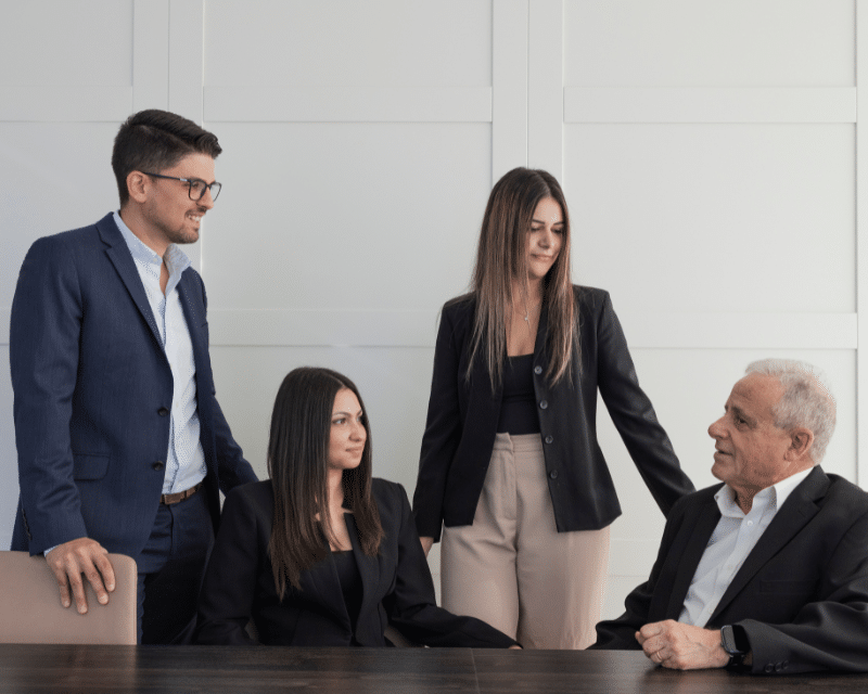 A2CO's Accounts Department posing for a photo in the board room, including Partner Clinton Cutajar, Cliona Testa Refalo, Chanel Borg and Joe Sacco while looking at each other