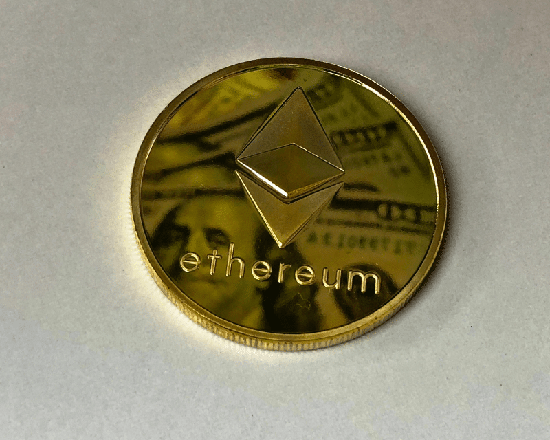 Close-up of a gold Ethereum coin with the Ethereum logo and text, symbolising cryptocurrency and blockchain technology.