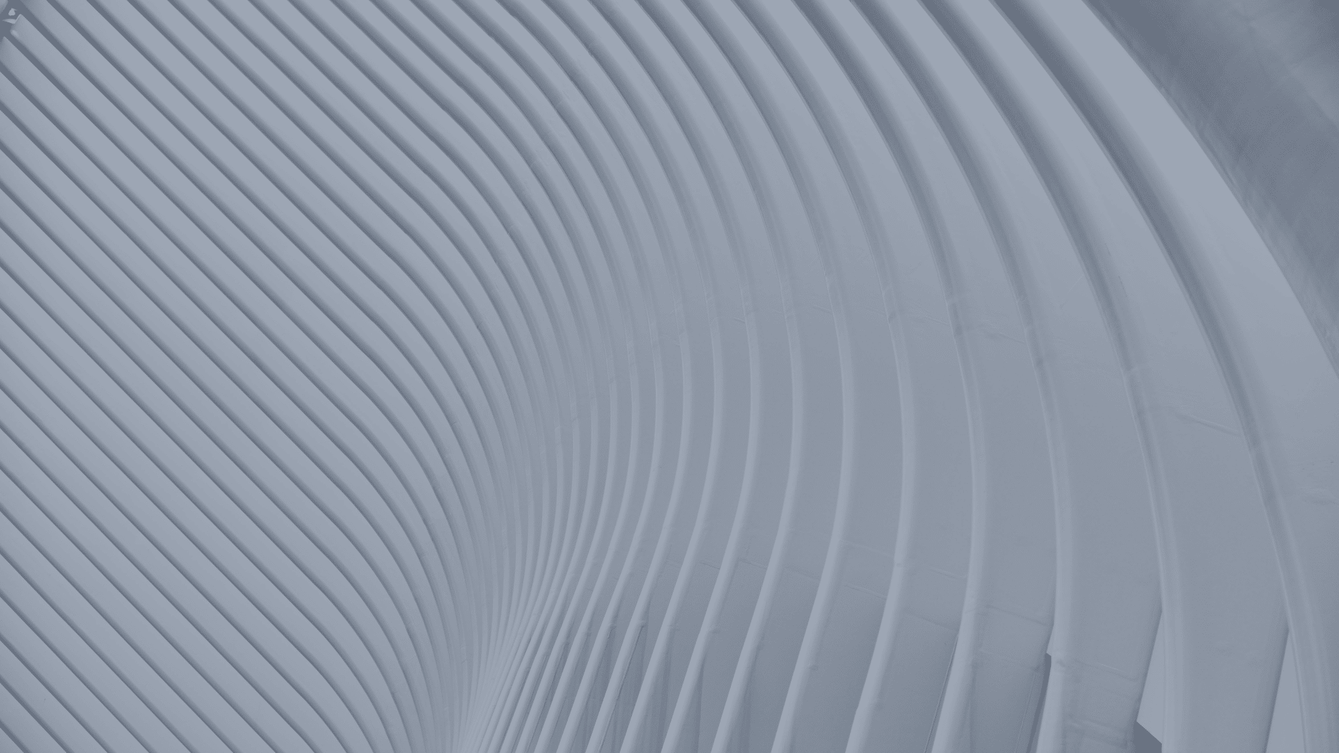 Abstract view of smooth lines which are curved architectural surfaces in blue tones.