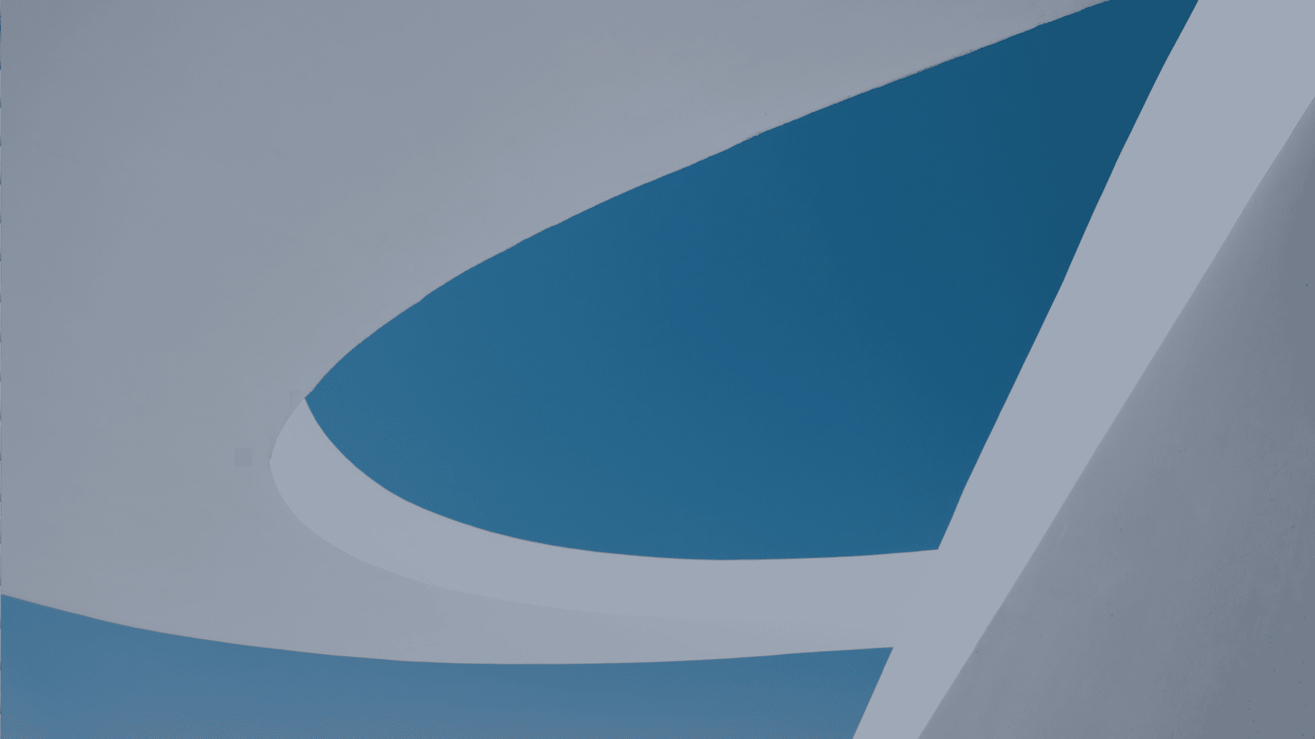 Abstract architectural detail with curved white structures framing a blue sky.