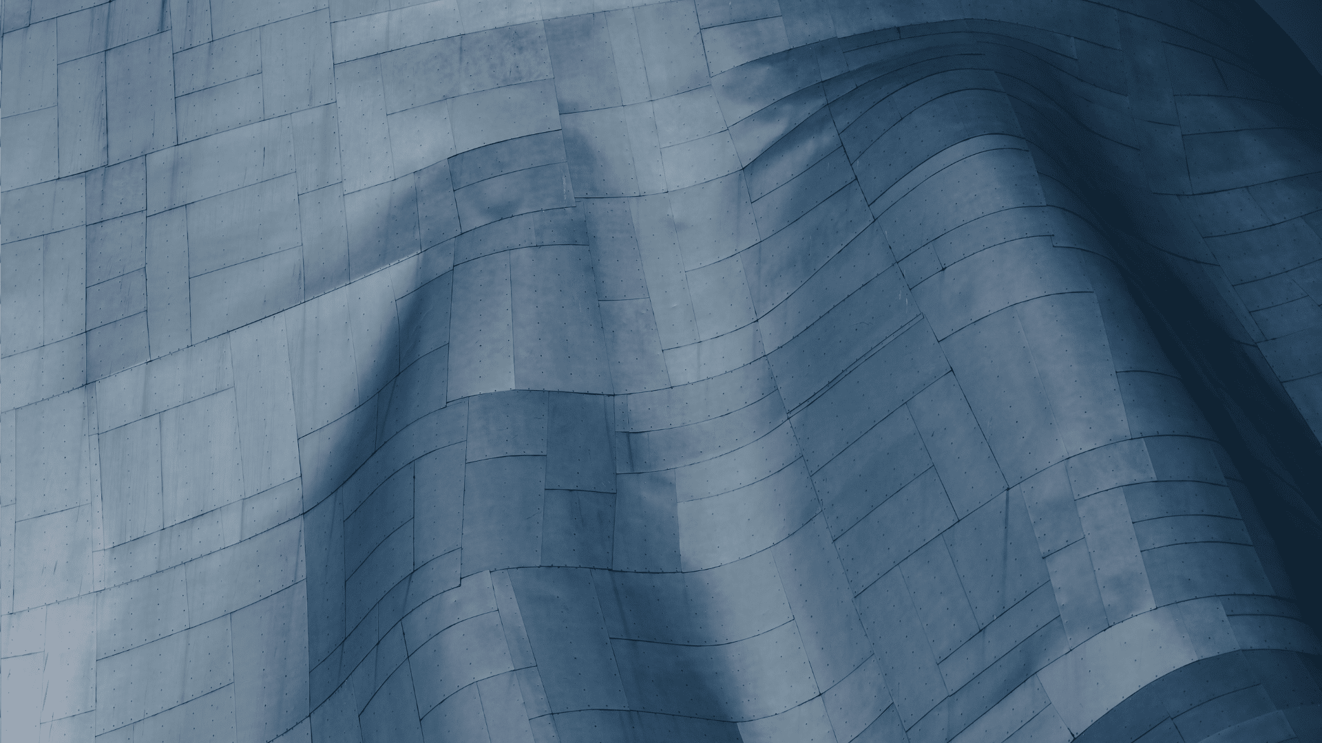 Abstract close-up of curved blue metal panels forming a modern architectural surface.