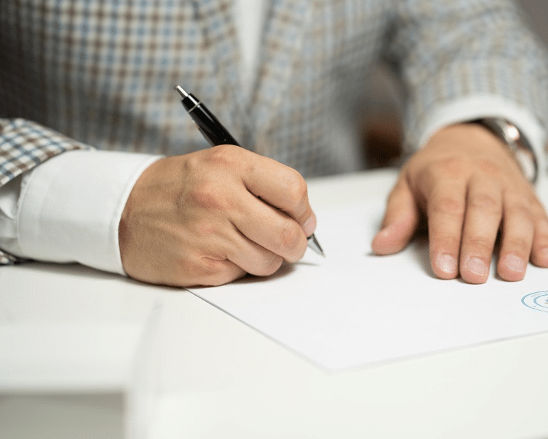 A2CO client signing business contract with professional guidance.