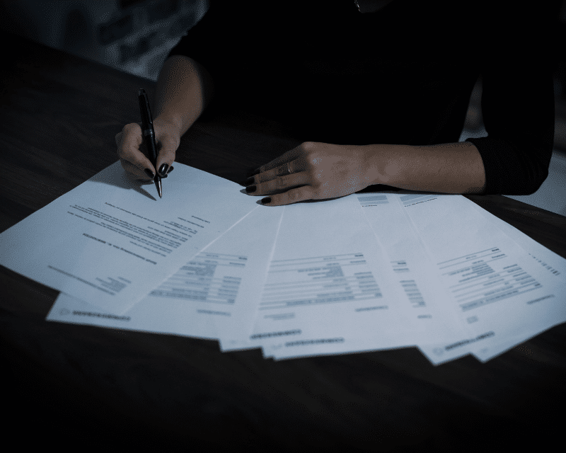 A2CO director signing official paperwork for client onboarding.