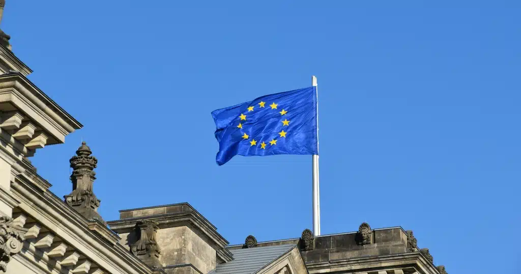 European Union flag flying above a government building, representing EU market access for crypto-asset service providers authorised under MiCA